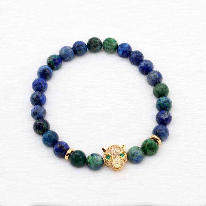 Circle bracelet with blue and green gemstone chrysocolla beads with gold spacers and a gold leopard head charm with green eyes.