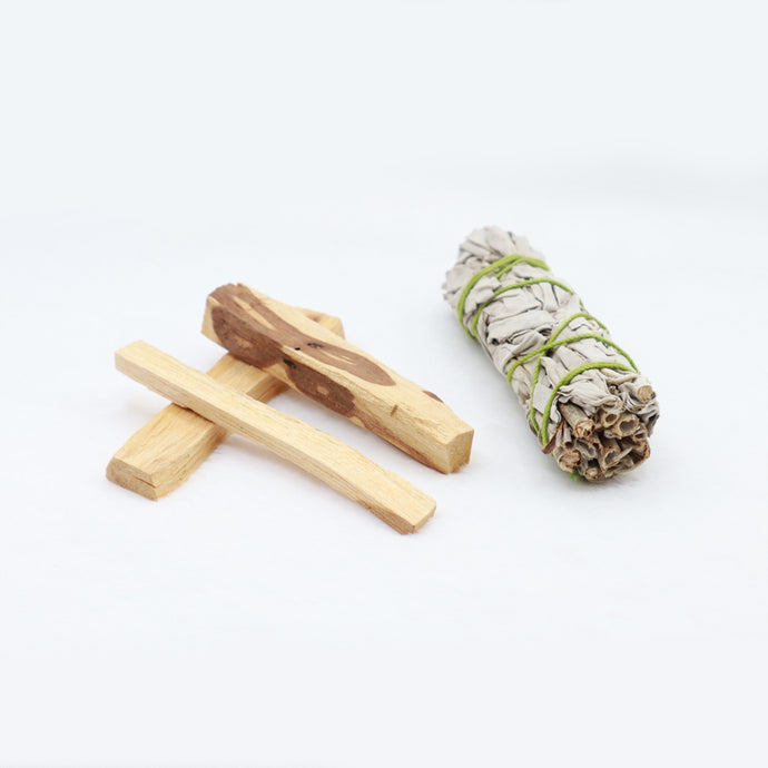 There are three Palo santo sacred wood pieces that is sweet smelling when burned. To the right of it is sage 